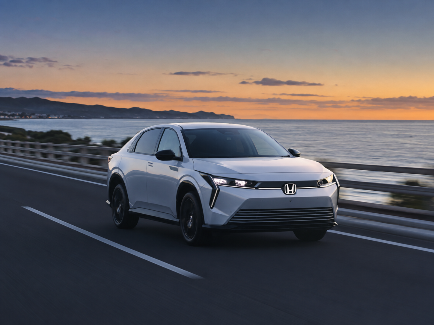 朝焼けの海岸沿い道路を走行するホワイトのホンダ 0シリーズ EV SUV